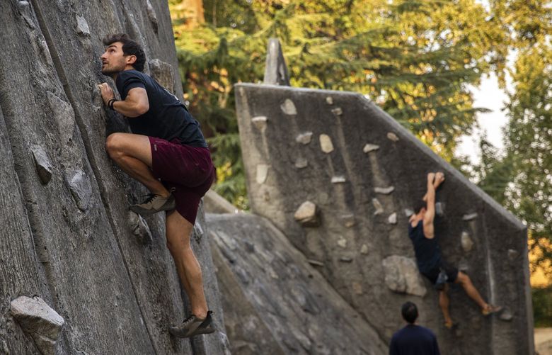 University of Washington employee Nick Franko, left, boulders Husky Climbing Rock, more commonly known as Husky Rock, located at the south end of Husky Stadium on Tuesday, September 7, 2021. For Franko, Husky Rock is “the best place in town to train and climb outside, especially for free.”

In 1970, climbers bouldering campus buildings had become a rising problem on the University of Washington campus, according to “Husky Rock: A Bouldering Guide to the U.W. Climbing Walls” by Scotty Hopkins and Erik Wolfe.

When the situation became worse, the University didn’t focus on stopping the bouldering attempts, but according to Hopkins and Wolfe, the university instead discussed building an artificial climbing wall.

After separate mountain climbing accidents tragically claimed the lives of two students and a faculty member in 1973, students urged the approval of the project so climbers could train properly and learn about safety, according to a Seattle Daily Times article. Plans for construction of the strenuous climbing rock was approved and went on to be designed and built from 1975-76 by architects Anderson and Bell. Today, Husky Climbing Rock is recognized as one of the first outdoor bouldering areas in the country, according to the authors.