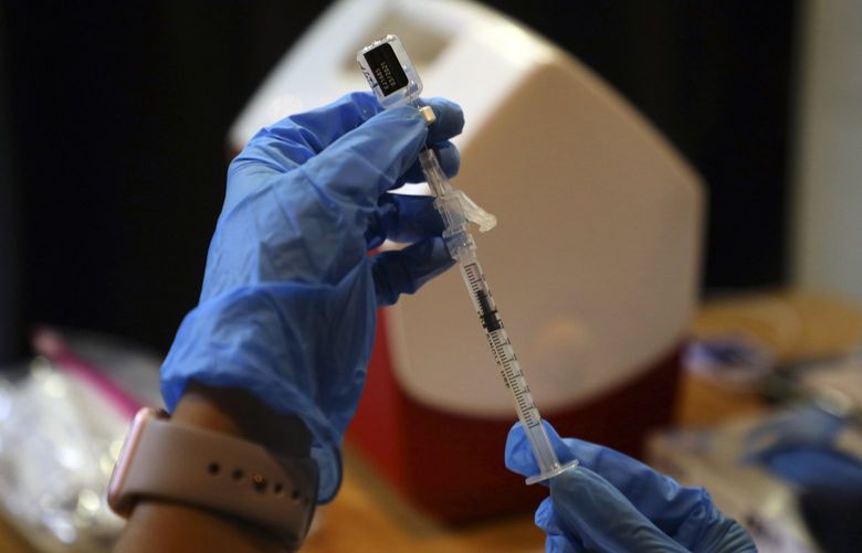 FILE – A syringe is filled with a dose of the Pfizer-BioNTech COVID-19 vaccine at a vaccine center in Rohnert Park, Calif. on Jan. 27, 2021. California’s requirement for all health care workers to be vaccinated against the coronavirus, which took effect Thursday, Sept. 30, 2021, appears to have compelled tens of thousands of unvaccinated employees to get shots in recent weeks, bolstering the case for employer mandates. (Jim Wilson/The New York Times) XNYT14 XNYT14