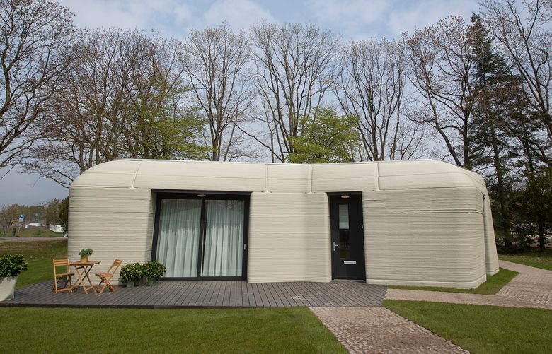 Exterior view showing the printer layers of the 3D-printed 94-square meters (1,011-square feet) two-bedroom bungalow resembling a boulder with windows in Eindhoven, Netherlands, Friday, April 30, 2021. The fluid, curving lines of its gray walls look natural. But they are actually at the cutting edge of housing construction in the Netherlands and around the world. They were 3D printed at a nearby factory. (AP Photo/Peter Dejong)
