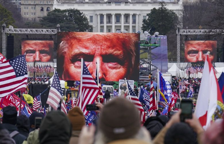 FILE – In this Jan. 6, 2021, file photo, the face of President Donald Trump appears on large screens as supporters participate in a rally in Washington. The House committee investigating the violent Jan. 6 Capitol insurrection, with its latest round of subpoenas in September 2021, may uncover the degree to which former President Donald Trump, his campaign and White House were involved in planning the rally that preceded the riot, which had been billed as a grassroots demonstration. (AP Photo/John Minchillo, File) NY932 NY932