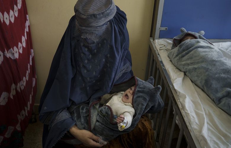A woman holds one of her two babies undergoing treatment at the malnutrition ward of the Indira Gandhi Children’s Hospital in Kabul, Afghanistan, Tuesday, Oct. 5, 2021. Health workers in the hospital dashed back and forth caring for gasping premature newborns and others suffering from severe malnutrition and other diseases. (AP Photo/Felipe Dana) XFD113 XFD113