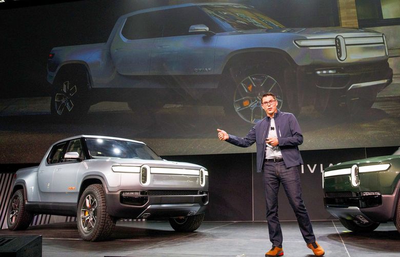 RJ Scaringe, founder and chief executive officer of Rivian Automotive Inc., unveils the R1T electric pickup truck, left, and R1S electric sports utility vehicle (SUV) during a reveal event at AutoMobility LA ahead of the Los Angeles Auto Show in Los Angeles, California, U.S., on Tuesday, Nov. 27, 2018. With its crew-cab and short bed, the R1T seems to be taking aim at the Ford F-150 Raptor.