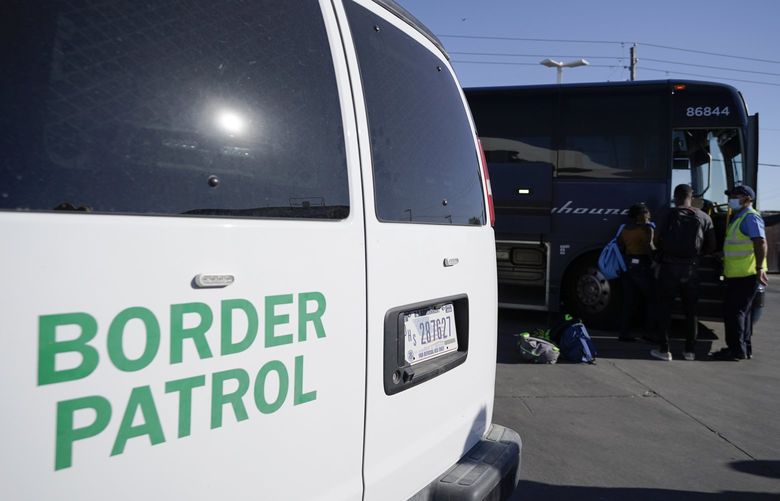 A U.S. Customs and Border Protection van is seen next to a bus picking up travelers, mostly migrants from Haiti released from CBP custody, at a gas station that serves as a bus terminal, Thursday, Sept. 23, 2021, in Del Rio, Texas. Migrants released are greeted by a humanitarian organization, which facilitates bus tickets to San Antonio as they continue their journey. On Friday, the camp on the U.S. side that once held as many as 15,000 mostly Haitian refugees was completely cleared. (AP Photo/Julio Cortez) TXJC202 TXJC202