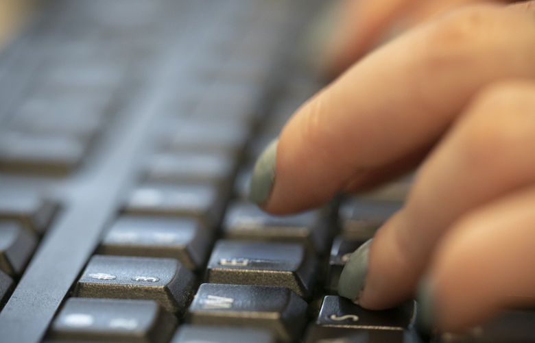 FILE – In this Oct. 8, 2019, file photo a woman types on a computer keyboard in New York. . (AP Photo/Jenny Kane, File)