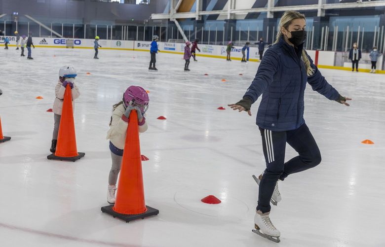 Volunteer skating coach Dasha Volnycheva, right, is followed by Amelie Wilke, 3, and other skating students gripping onto safety cones at a “Learn to Skate” class held at the Kraken Community Iceplex in Seattle on Oct. 6, 2021. The program encourages novice skaters of all ages from young kids to adults to learn various techniques of ice skating.  218440