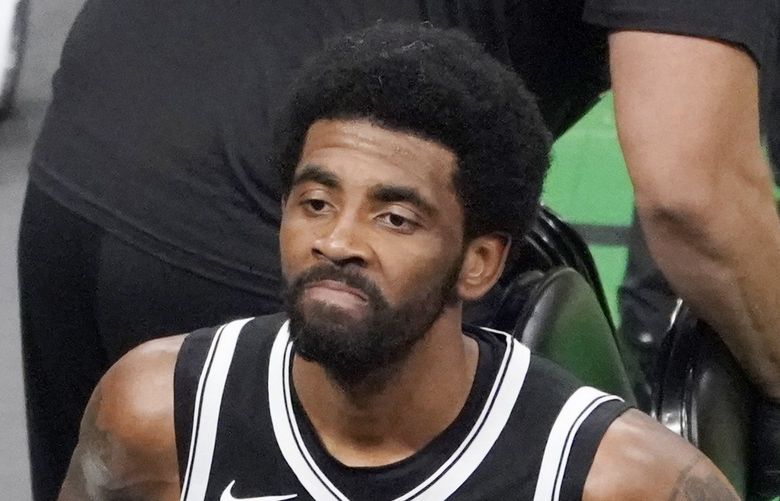 FILE – Brooklyn Nets guard Kyrie Irving looks up at the fans at TD Garden after they defeated the Boston Celtics in Game 4 during an NBA basketball first-round playoff series in Boston, in this Sunday, May 30, 2021, file photo. The Brooklyn Nets won’t play Kyrie Irving until he can play in all their games, unwilling to let questions about his vaccination status linger into the season. The Nets announced Tuesday, Oct. 12, 2021, that Irving would not play or practice with them until he could be a full participant, ending the idea that he would play in only road games. Without mentioning his vaccination status, general manager Sean Marks said Irving has made a decision that keeps him from being able to perform with the team. (AP Photo/Elise Amendola, File)