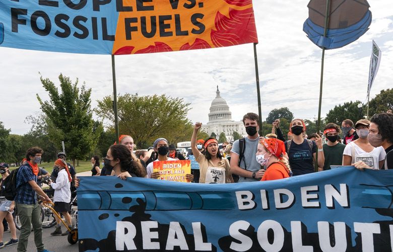 Climate and indigenous activists walk into the intersection of Pennsylvania and 3rd St NW during a climate change protest, Friday, Oct. 15, 2021, by the U.S. Capitol in Washington. (AP Photo/Jacquelyn Martin) DCJM120 DCJM120