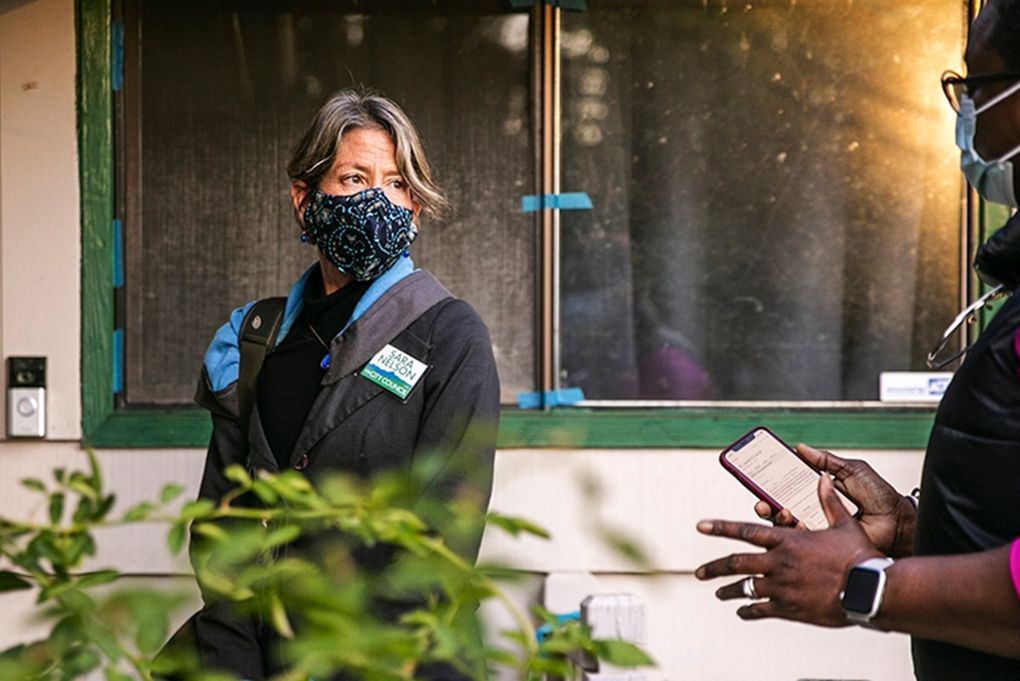 Seattle City Council Position 9 candidate Sara Nelson speaks with campaign volunteer Veniese Whittingham right, while canvassing in the Lake City area.(Amanda Snyder / The Seattle Times)