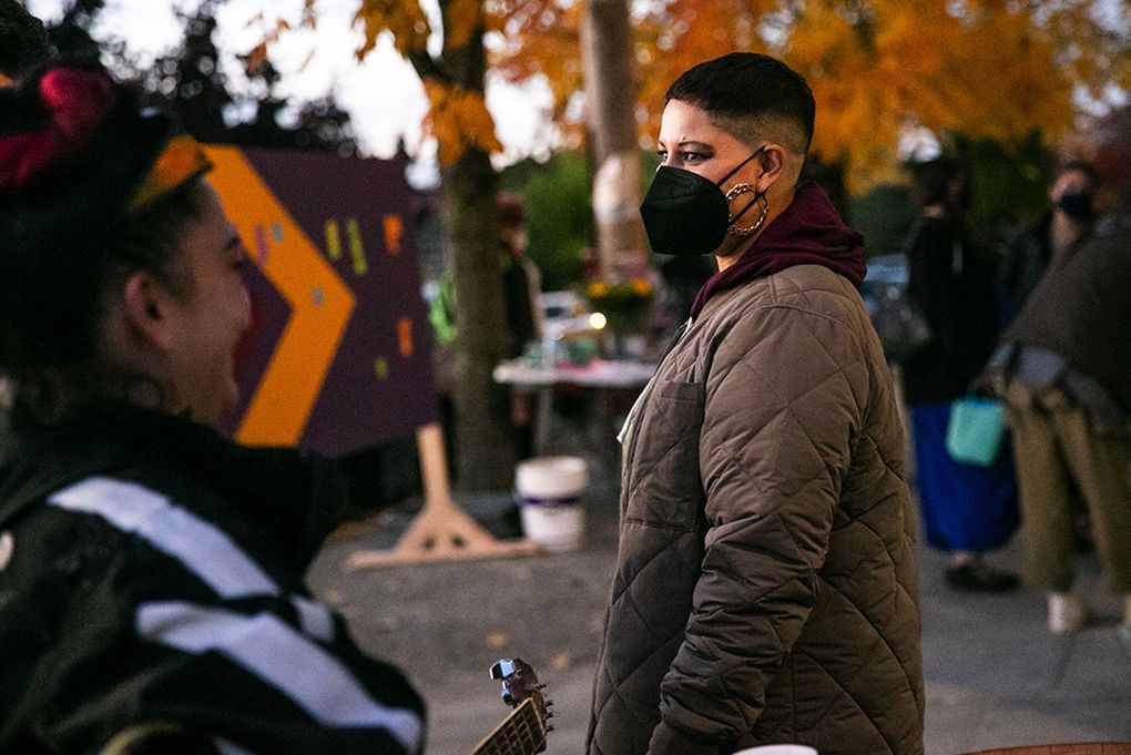 Seattle City Council Position 9 candidate Nikkita Oliver speaks with an attendee at a “listening post” event. (Amanda Snyder / The Seattle Times)