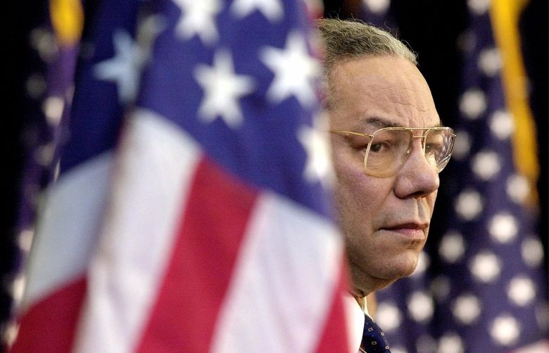 FILE – In this Feb. 15, 2001 file photo, Secretary of State Colin Powell looks on as President Bush addresses State Department employees at the State Department in Washington. Powell, former Joint Chiefs chairman and secretary of state, has died from COVID-19 complications, his family said Monday, Oct. 18, 2021. (AP Photo/Kenneth Lambert) WX101 WX101