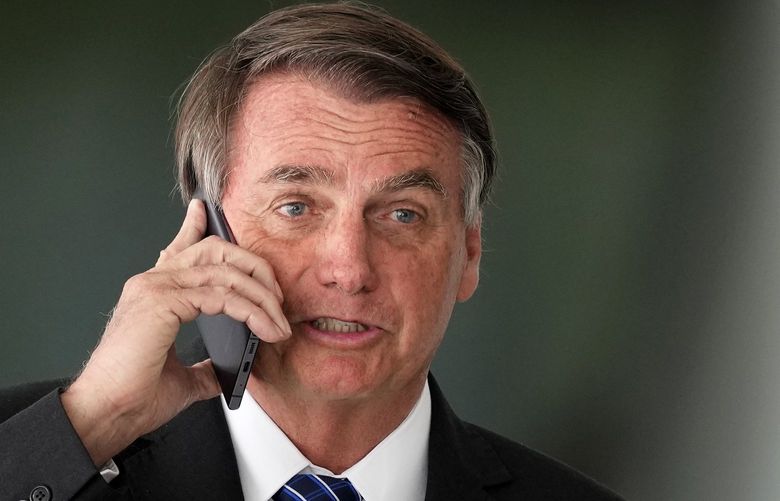 Brazilian President Jair Bolsonaro talks on cell phone after meeting with Colombia’s President Ivan Duque at Planalto presidential palace in Brasilia, Brazil, Tuesday, Oct. 19, 2021. Duque is on a two-day visit to Brazil. (AP Photo/Eraldo Peres) XEP121 XEP121