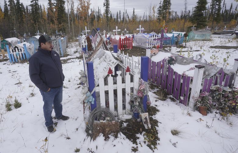 Herbie Demit, Tanacross Village Council president, walks through a cemetery Thursday, Sept. 23, 2021, in Tanacross, Alaska. Alaska is experiencing one of the sharpest rises in COVID-19 cases in the country, coupled with a limited statewide healthcare system that is almost entirely reliant on Anchorage hospitals. Tanacross, a village of about 140 residents, has recorded only one death, and only about 20 residents contracted the virus during the pandemic. (AP Photo/Rick Bowmer) FX309 FX309