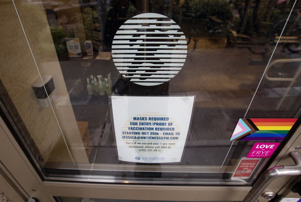 A sign on the door of NW Fitness Gym, in downtown Seattle, telling patrons that masks and proof of COVID-19 vaccines are required for entry. (Ken Lambert / The Seattle Times)