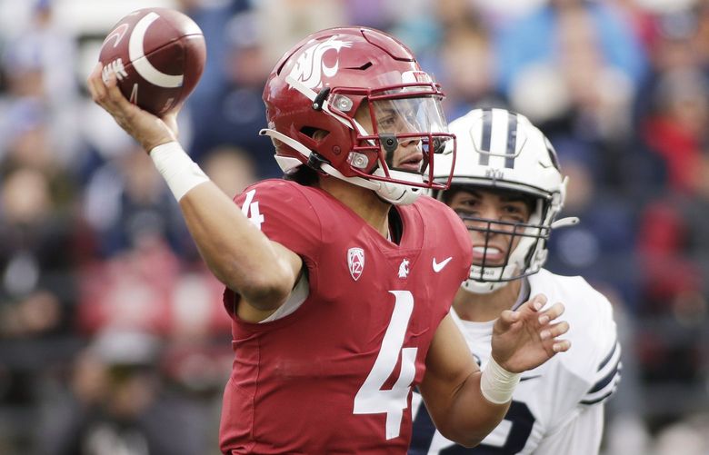 Washington State quarterback Jayden de Laura, left, throws a pass while pressured by BYU defensive lineman Tyler Batty during the second half of an NCAA college football game, Saturday, Oct. 23, 2021, in Pullman, Wash. (AP Photo/Young Kwak) OTK OTK
