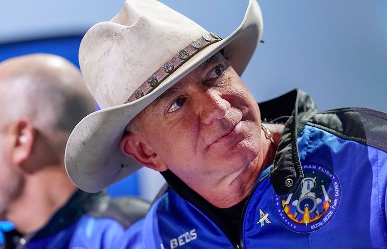 Mark Bezos, left, and Jeff Bezos, right, founder of Amazon and space tourism company Blue Origin, watch a video playback of their flight experience from the spaceport near Van Horn, Texas, Tuesday, July 20, 2021. (AP Photo/Tony Gutierrez) TXTG144 TXTG144
