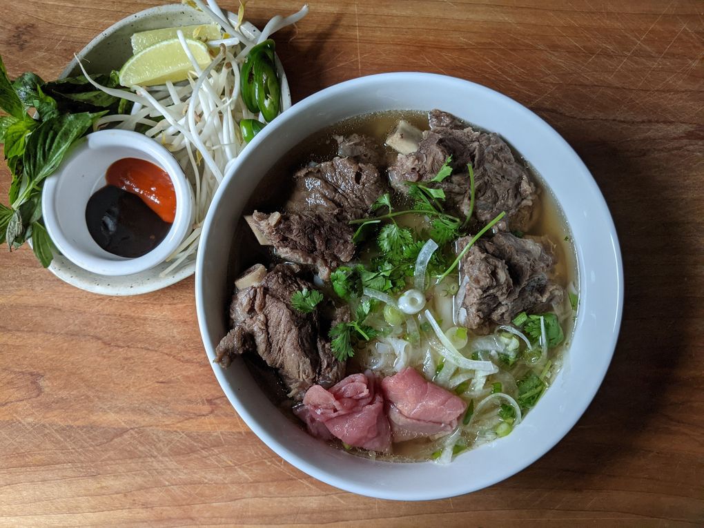 Pho Joe’s offers substantial bowls of pho, the broth slicked with fat and bobbing with a wide, flat rice noodle, beef ribs and rare beef. (Jackie Varriano / The Seattle Times)