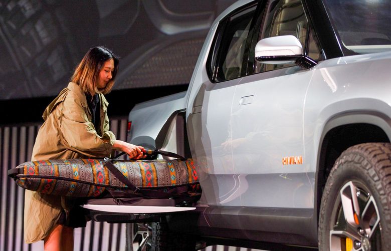 A person demonstrates how the side cargo compartment of a Rivian Automotive Inc. R1T electric pickup truck can be used during a reveal event at AutoMobility LA ahead of the Los Angeles Auto Show in Los Angeles, California, U.S., on Tuesday, Nov. 27, 2018. With its crew-cab and short bed, the R1T seems to be taking aim at the Ford F-150 Raptor. Photographer: Patrick T. Fallon/Bloomberg 775264210