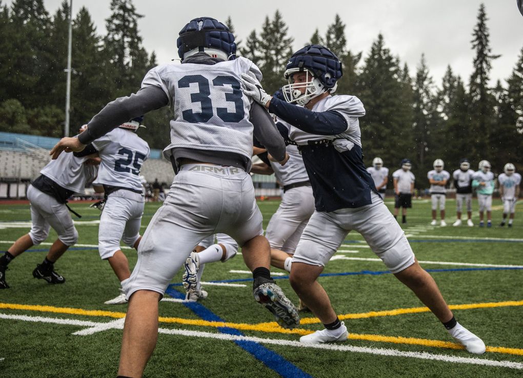 Zach Mclean, right, practices a play during a football practice at Interlake High School in Bellevue on Wednesday, Oct. 27, 2021. Mclean who is legally blind is a junior at Interlake High School. (Daniel Kim / The Seattle Times)