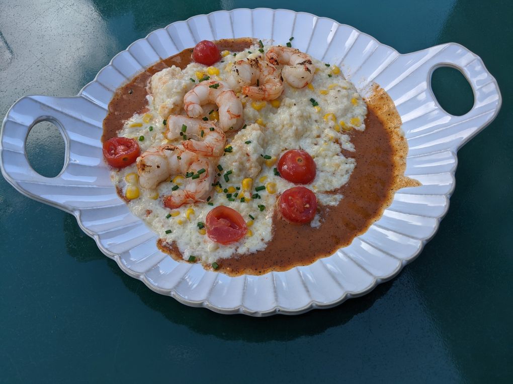 The shrimp and grits at Kenmore’s recently opened Cedar + Elm features thick, cheesy grits served atop a spicy tomato broth. (Jackie Varriano / The Seattle Times)