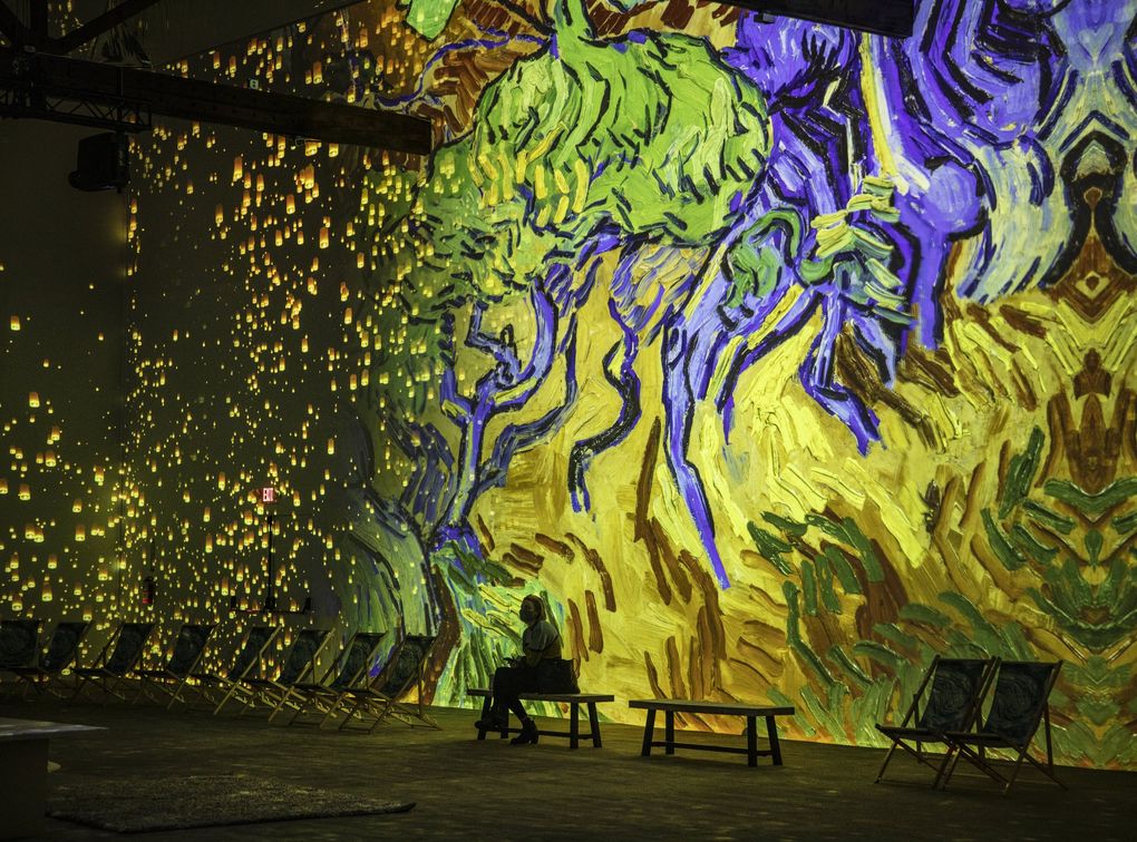 In the 8,000-square-foot immersive room of “Van Gogh: The Immersive Experience,” the wall projections transition from Van Gogh’s “Tree Roots” to his “The Starry Night.” (Steve Ringman / The Seattle Times)