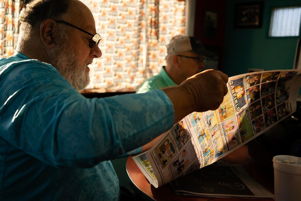 “They’ve just really gone downhill” since being purchased by Gannett, said Richard Rosenbury of The Burlington Hawk Eye, which he is seen reading at Jerry’s Main Lunch in Burlington, Iowa, in August 2021. (KC McGinnis for The Atlantic / TCA)