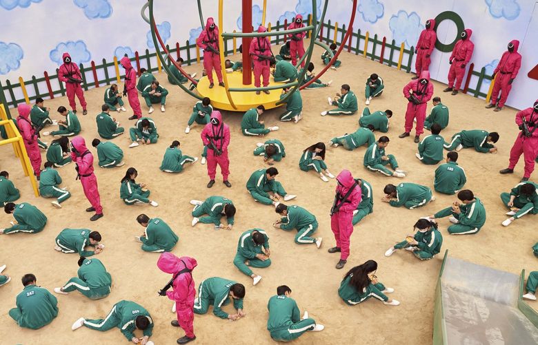 This undated photo released by Netflix shows a scene of contestants vying to win the Dalgona Korean candy challenge in a scene from “Squid Game.” Squid Game, a globally popular South Korea-produced Netflix show that depicts hundreds of financially distressed characters competing in deadly childrenâ€™s games for a chance to escape severe debt, has struck a raw nerve at home, where thereâ€™s growing discontent over soaring household debt, decaying job markets and worsening income inequality. (Youngkyu Park/Netflix via AP) XJP803 XJP803