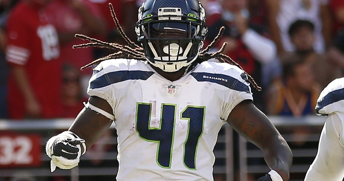 Seattle Seahawks running back Alex Collins is wrapped up by Los Angeles Rams  defensive tackle Sebastian Joseph-Day (69) as he rushes during the first  half of an NFL football game, Thursday, Oct.