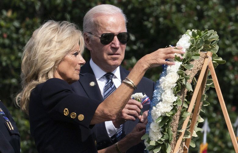 President Joe Biden watches first lady Jill Biden touches the flowers on a wreath during a ceremony honoring fallen law enforcement officers at the 40th annual National Peace Officers’ Memorial Service at the U.S. Capitol in Washington, Saturday, Oct. 16, 2021. (AP Photo/Manuel Balce Ceneta) DCMC106 DCMC106