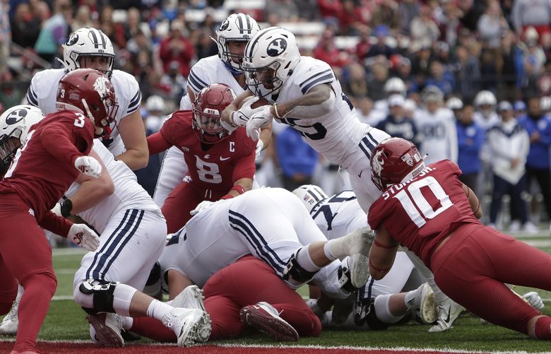 BYU running back Tyler Allgeier, top center, reaches for a touchdown during the second half of an NCAA college football game against Washington State, Saturday, Oct. 23, 2021, in Pullman, Wash. BYU won 21-19. (AP Photo/Young Kwak) WAYK116 WAYK116