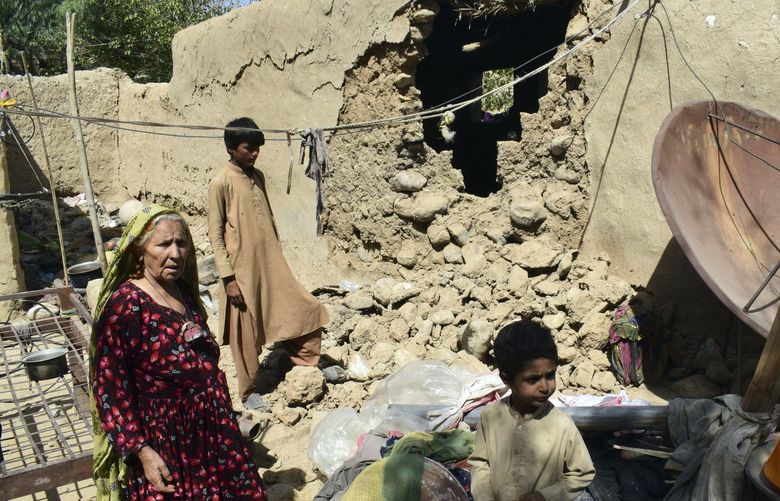 A family is seen inside their house following an earthquake in Harnai, about 100 kilometers (60 miles) east of Quetta, Pakistan, Thursday, Oct. 7, 2021. The powerful earthquake collapsed at least one coal mine and dozens of mud houses in southwest Pakistan early Thursday. (AP Photo/Arshad Butt) XRG101 XRG101