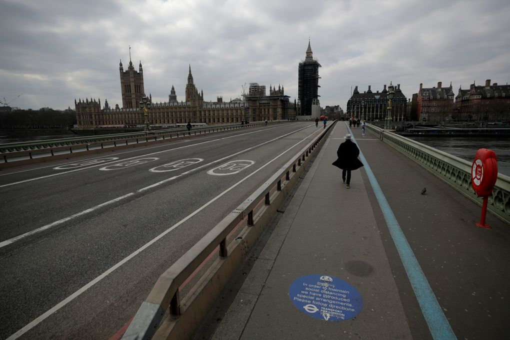 FILE – In this Tuesday, March 23, 2021 file photo, people pass over a quiet Westminster Bridge, backdropped by the scaffolded Houses of Parliament and the Elizabeth Tower, known as Big Ben, in London, during England’s third coronavirus lockdown. The British government waited too long to impose a lockdown in the early days of the COVID-19 pandemic, missing a chance to contain the disease and leading to thousands of unnecessary deaths, lawmakers concluded Tuesday, Oct. 12, 2021 in a hard-hitting report. (AP Photo/Matt Dunham, File)
