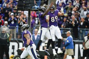 Baltimore Ravens tight end Mark Andrews (89) walks with a U.S. service  member before being introduced on the field as part of the team's Salute to  Service prior to an NFL football