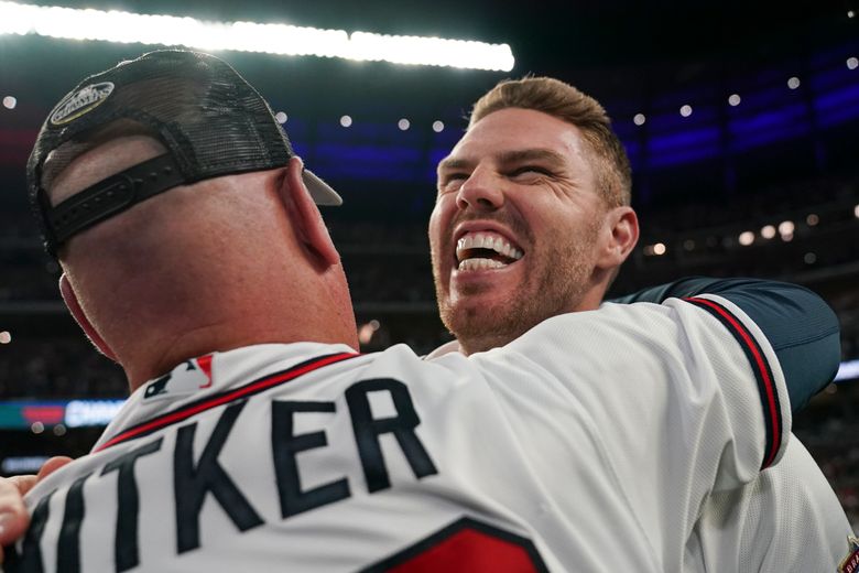 Atlanta Braves manager Brian Snitker, left, talks with a fan