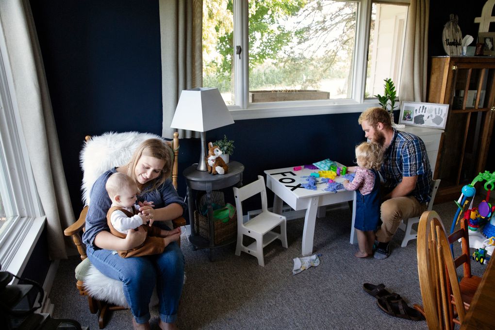 Kayleigh Fox, a 27-year-old nurse in Walkerville, Mich., survived COVID-19 and delivered her son Oak Fox, whom she is holding. They are pictured with her husband, Noah Fox, and daughter, Addisyn, at home on Sept. 15. She describes her ordeal in a commercial for her state’s health department urging pregnant women to get the vaccine. (Photo for The Washington Post by Kyle Monk)
