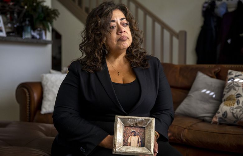 Teresa Alvarado becomes emotional Sept. 14, 2021, while holding a photo of her son, Keenan Thomas, who died at the Walla Walla State Penitentiary in 2019. The state of Washington has settled a lawsuit in his death for $3 million. (Amanda Snyder / The Seattle Times)