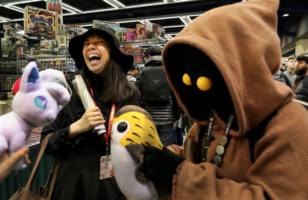 Michaele Razi, left, dressed as a witch from “Harry Potter,” gets a kick out of Jackie Yeo’s Jawa costume from “Star Wars” during the 2019 Emerald City Comic Con. The event returns Dec. 2-5 at the Washington State Convention Center for the first time since the pandemic forced the cancellation of the 2020 event. (Alan Berner / The Seattle Times)