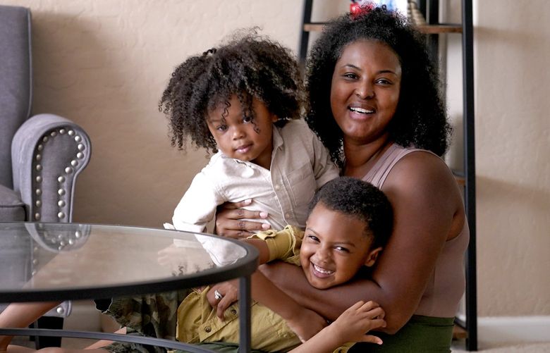 Kisha Gulley appears with her sons Sebastian, 2, left, and Santana, 5, Friday, Sept. 3, 2021 in Phoenix. Gulley is an Instagram influencer and blogger who generates income from her content. (AP Photo/Matt York) AZMY203 AZMY203