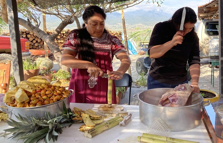 Juanita Ruiz Gutierrez, 46, and Elizabeth Gomez, 33, prepare fruit to add to a special mezcal for the Day of the Dead in Santiago Matatlan. (Leila Miller/Los Angeles Times/TNS) 31093329W 31093329W