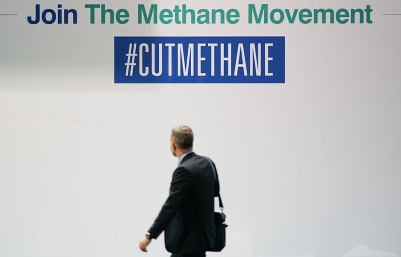 A man walks past a board advertising the Methane Movement on day two of the COP 26 United Nations Climate Change Conference at SECC on Nov. 1, 2021 in Glasgow, Scotland. (Ian Forsyth/Getty Images/TNS) 31093829W 31093829W