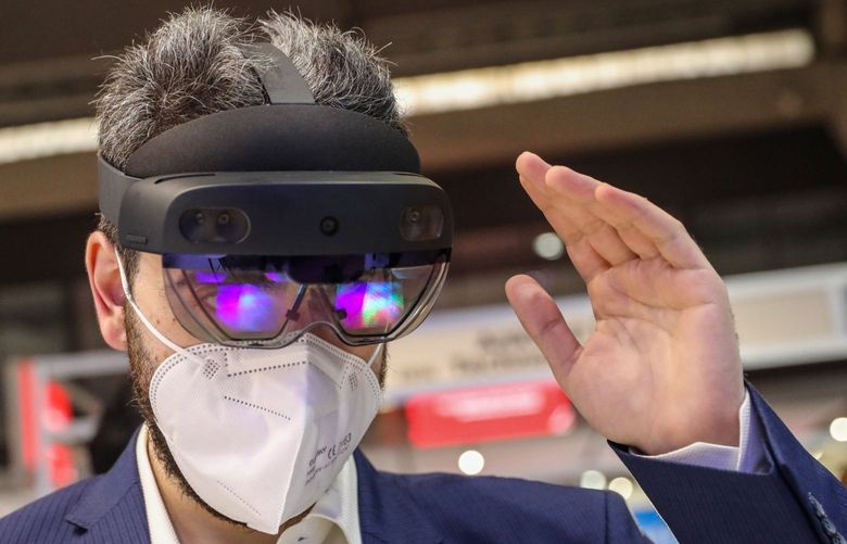An attendee wearing a protective face mask tries out a Microsoft Corp. HoloLens 2 headset on the opening day of the MWC Barcelona at the Fira de Barcelona venue in Barcelona, Spain, on Monday, June 28, 2021. MWC Barcelona, which in 2019 attracted 109,000 attendees from 198 countries, was one of the first major European conference casualties due to the pandemic when it was axed in February last year. 775673495