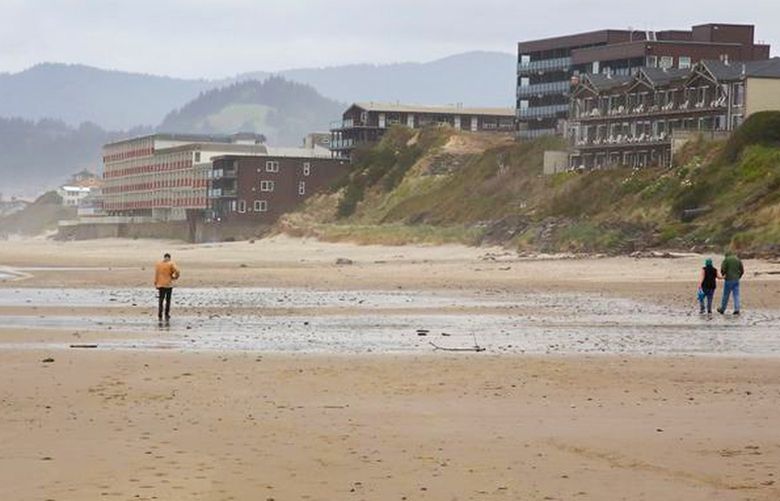 People walk along Wecoma Beach in Lincoln City on the central Oregon coast, July 5, 2021. 18218983P