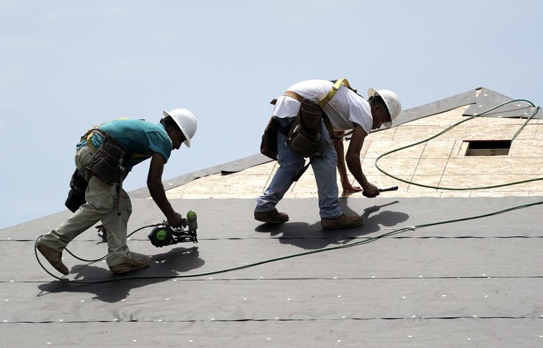 FILE- In this July 23, 2018, file photo construction workers put down roofing paper on home in Houston. (AP Photo/David J. Phillip, File)