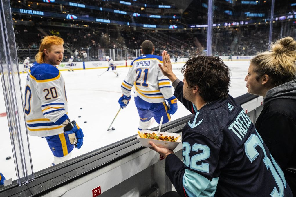 Erike Trefzger tries to get the attention of Buffalo’s Cody Eakin recently — his favorite player growing up. (Dean Rutz / The Seattle Times)