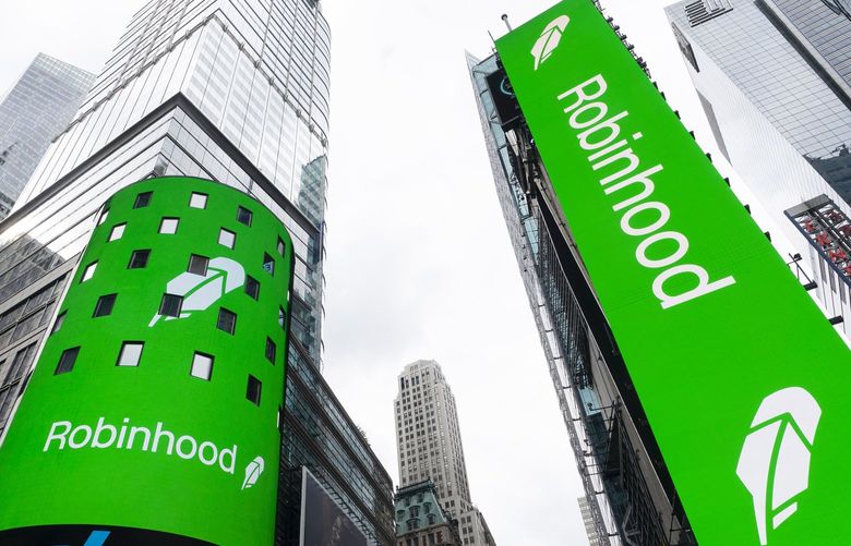 Electronic screens in New York’s Times Square announce the Robinhood IPO, Thursday, July 29, 2021. Robinhood has already changed how people trade stocks and who’s doing it. Now its sights are on the rest of the financial industry. (AP Photo/Mark Lennihan) NYML106