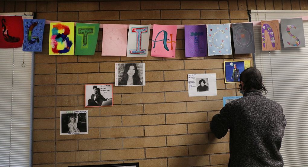 Kent Youth and Family Services, a recipient of The Seattle Times Fund for Those in Need, has a weekly arts-focused LGBTQ+ support group for young people. Here, group participant Beetle Howe hangs photos of LGBTQ+ icons. (Bettina Hansen / The Seattle Times)