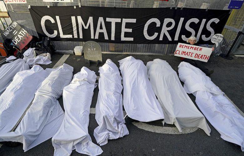 Climate activists dressed as shrouded bodies protest near the venue for the COP26 U.N. Climate Summit in Glasgow, Scotland, Thursday, Nov. 11, 2021. (Andrew Milligan/PA via AP) TH802 TH802
