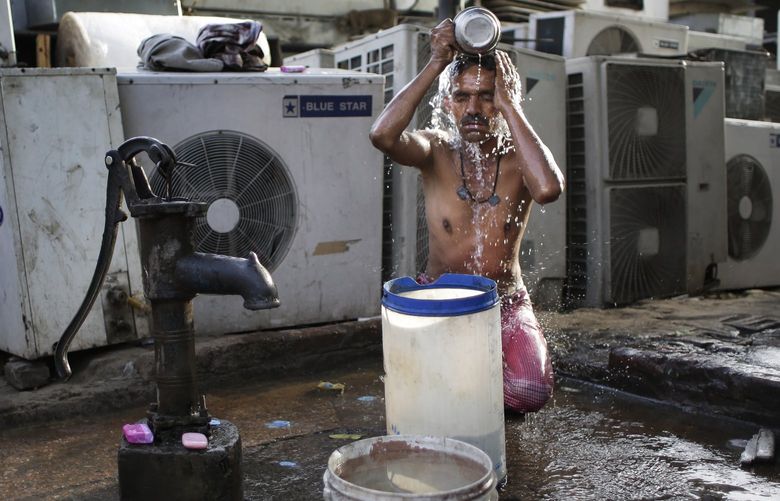 FILE – A migrant daily wage worker bathes at a public well pump on a hot morning in New Delhi, India, Tuesday, May 17, 2016. Scorching summer temperatures, hovering well over 40 degrees Celcius, (104 Fahrenheit) are making life extremely tough for millions of poor across north India. Without access to air conditioning and sometimes even an electric fan, they struggle to cope with the heat in their inadequate homes. (AP Photo/Altaf Qadri, File) NY581 NY581