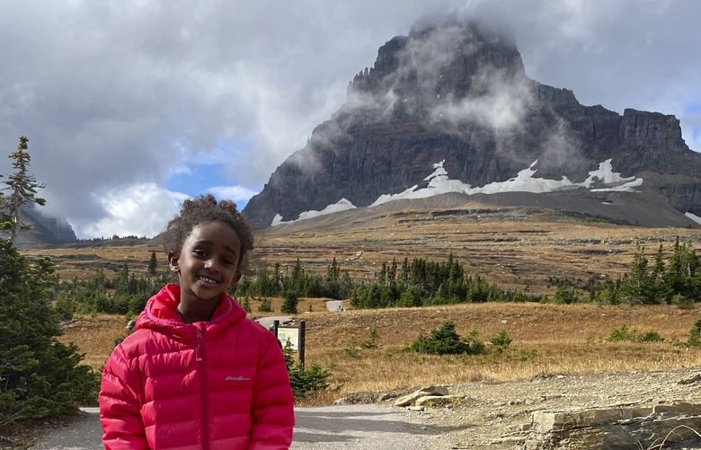 In this photo provided by Ben Pascal, five-year-old Naomi Pascal, holding her teddy bear, is pictured on a hike to Hidden Lake in Glacier National Park, Mont., in October 2020. Naomi lost the bear while on the hike, but it was found by a park ranger who took care of the bear until it was spotted on the dash of his ranger truck and returned to Naomi this fall. (Ben Pascal via AP) FX501 FX501