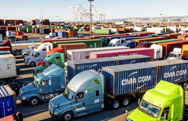 Trucks line up to enter a Port of Oakland shipping terminal on Wednesday, Nov. 10, 2021, in Oakland, Calif. Intense demand for products has led to a backlog of container ships outside the nation’s two largest ports along the Southern California coast. (AP Photo/Noah Berger) CANB106