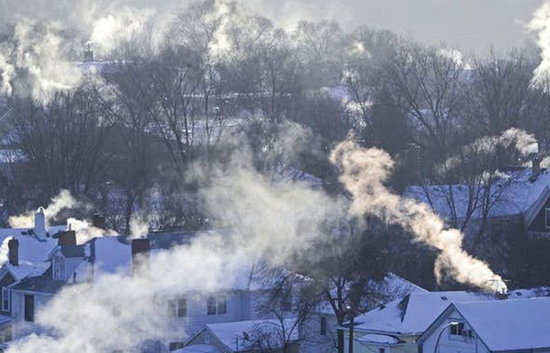 Smoke rises from the chimneys of homes in St. Paul’s West 7th neighborhood in 2019, as furnaces tried to keep up with record breaking cold. 1456437